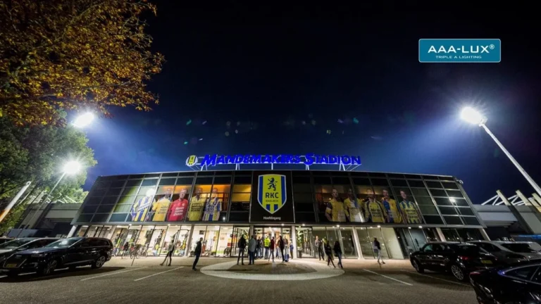 Hoofdingang van het Mandemakers Stadion van RKC Waalwijk bij avond, met brandende LED stadionverlichting